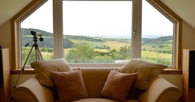 Large tilt and turn window with angled fixed panes finished with royal oak timber sills and surrounds