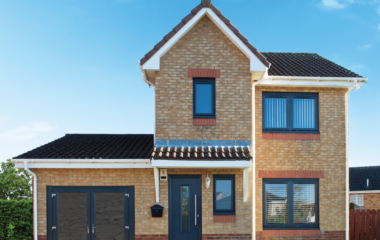 External view of a property with anthracite grey windows, front door and french doors