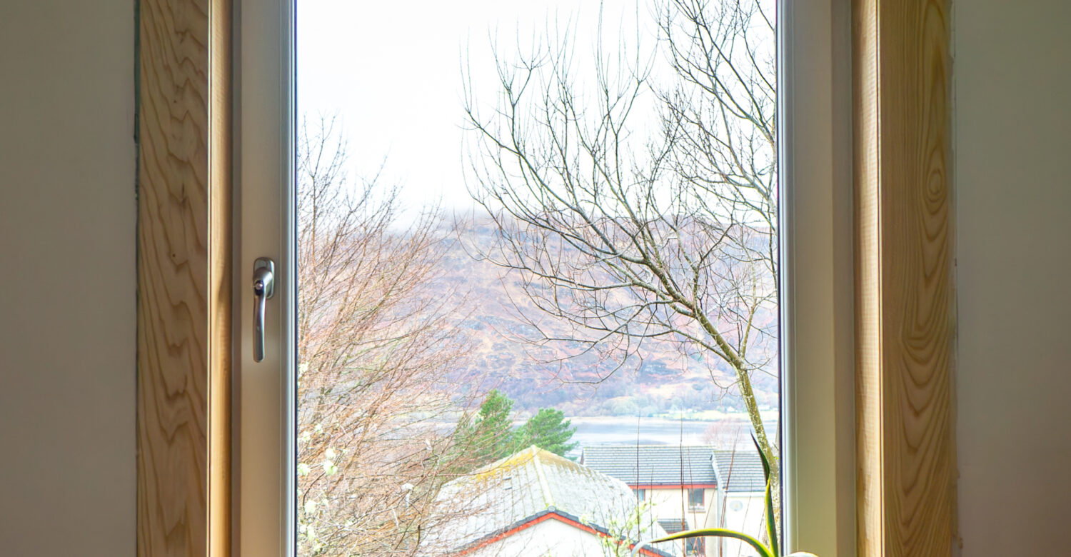 A white uPVC casement window complete with royal oak timber sills and surrounds at a Fort William Installation.