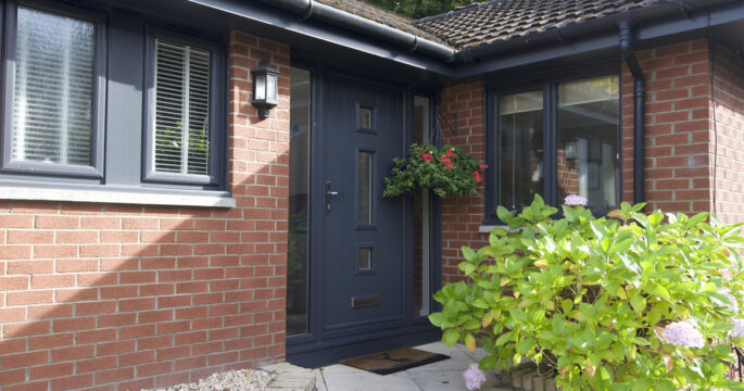 Exterior shot of a front door in an anthracite finish. Complete with two frosted glass side screen