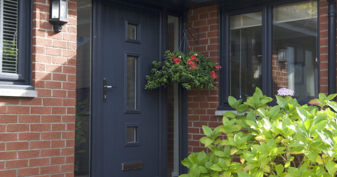 Exterior shot of a front door in an anthracite finish. Complete with two frosted glass side screen